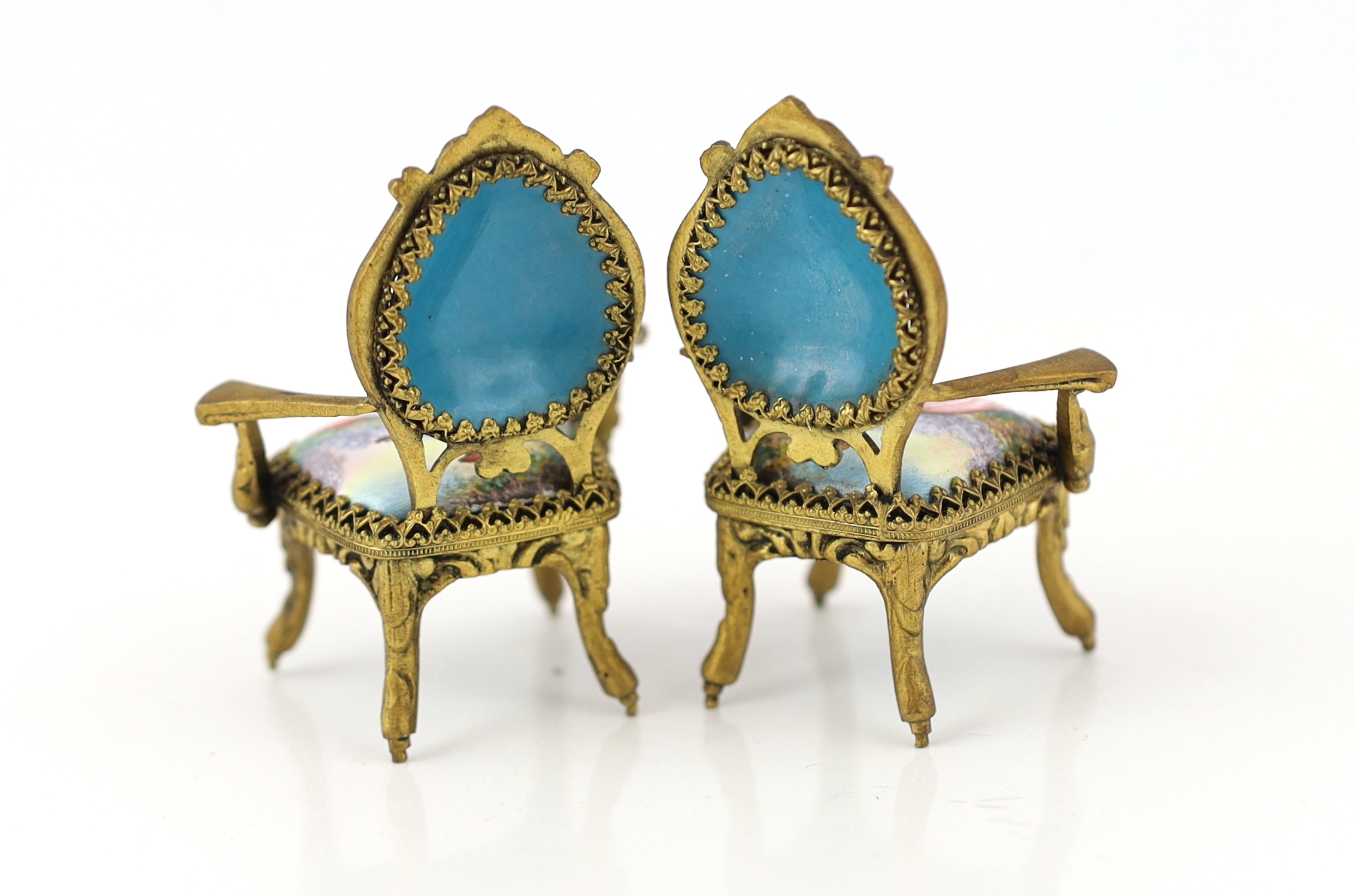 A 20th century Swiss enamel and ormolu musical miniature doll's house table with a pair of matching salon chairs, table 9.5 x 7.5cm, 5cm high, chairs 7cm high